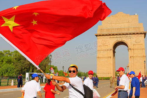 图文:海外华人在传递终点印度门前挥动五星红旗