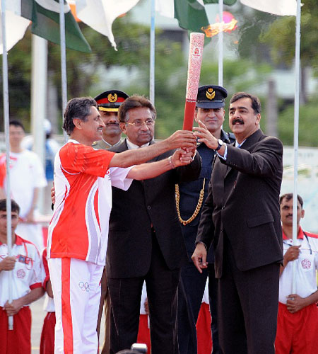 4月16日，在巴基斯坦体育中心，巴基斯坦总统穆沙拉夫（中）、总理吉拉尼（右）将火炬交给第一棒火炬手、1976年奥运会曲棍球铜牌获得者萨米乌拉·汗（左）。 新华社记者安治平摄 
