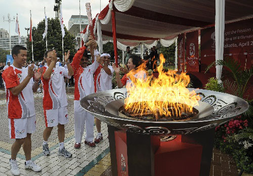4月22日，陶菲克（左一）等火炬手共同点燃圣火盆后欢呼。当日，北京奥运会圣火传递活动在印度尼西亚雅加达举行。这是北京奥运会圣火境外传递的第十四站。 新华社记者戚恒摄  