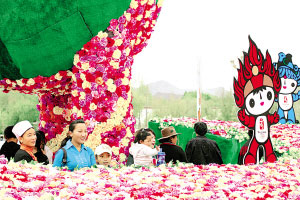 5月1日的布达拉宫广场鲜花绽放,游人如织。图为拉萨市民争相在迎奥运福娃卡通前合影留念。记者 格桑吉美 摄 