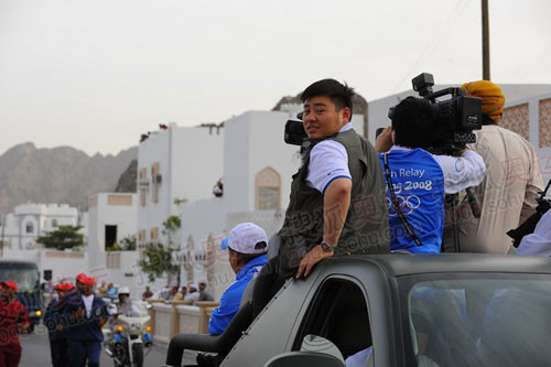 官网记者王非被迫站在小媒体车上拍摄（李东雷摄）