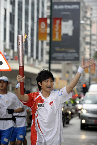 炬手、香港艺人古巨基在进行传递。   新华社记者戚恒摄