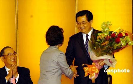 图为胡锦涛在欢迎宴会上接受献花。 中新社发 朱沿华 摄