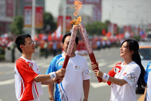 奥运火炬手赵薇（右）与徐有忠在传递过程中交接。当日，北京奥运圣火在安徽芜湖传递。