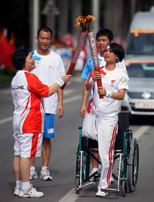 图文奥运圣火在广西南宁传递谢芳秋交接火炬