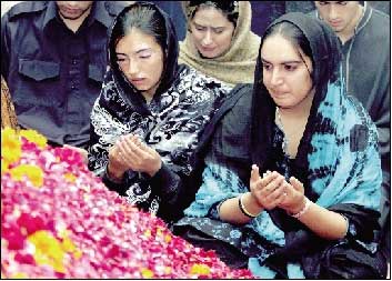  2007年12月29日，在巴基斯坦南部信德省胡达巴赫什堡村，贝·布托的两个女儿巴克塔瓦尔（右）和阿西法在母亲墓前祈祷。新华社/法新