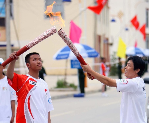 6月11日,奧運火炬手陳建力(右)與雲丹桑珠在傳遞過程中交接.