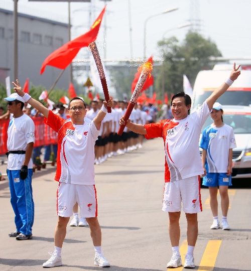 图文:奥运圣火在太原传递 曹太明与贺虹交接