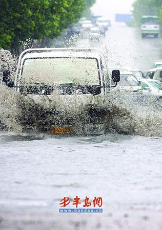 车辆在洛阳路与重庆南路路口涉水通行。本报记者 张伟 摄