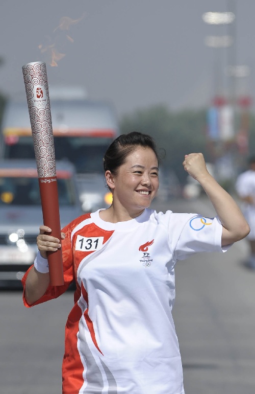 图文:火炬手孙燕传递火炬打出爱心手势