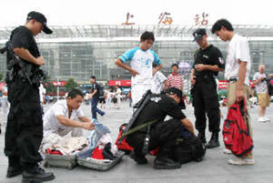 昨日，持枪特警在上海火车站广场检查乘客行李。早报见习记者 黄敬亮 图
