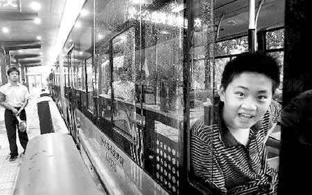 图中小男孩自称4时就来等车了。他调皮地告诉记者：“我是为了坐新公交车才来的，还买了好几张纪念车票呢。”他刚说完车就开走了 文并摄/记者柴程