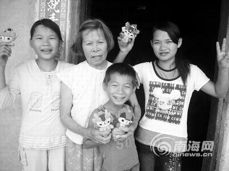 梁阿婆和3个孙儿拿着“福娃”很快乐