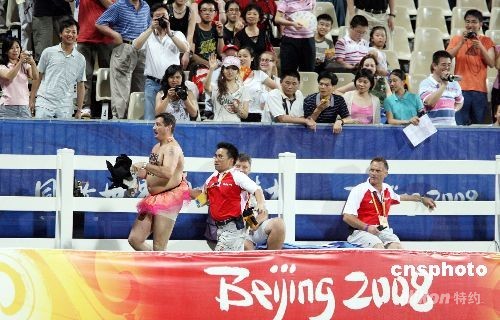 　八月二十一日晚，在香港举行的奥运马术项目比赛进行最后一天赛事，场內一观众着奇裝跑入赛场，被保安驱赶出场。中新社发 洪少葵 摄 