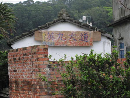 通往马家庄的路边三合院墙上挂着“英九大道”的牌子，这条路本是苗栗县道，只有区区八米宽。