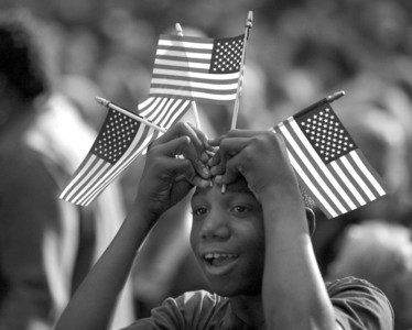 一个黑人小男孩举着美国国旗欢呼