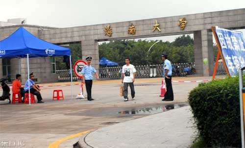 2008年11月4日，一名学生正走出海南大学北大门外的第二道警戒线。