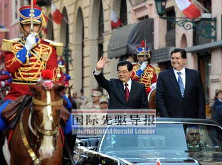 11月19日，国家主席胡锦涛抵达利马，开始对秘鲁进行国事访问。图为胡锦涛主席在加西亚总统举行的隆重欢迎仪式上，乘敞篷车向欢迎群众挥手致意。本报记者樊如钧/摄
