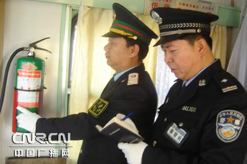 图为列车乘警长和列车长共同进行消防检查