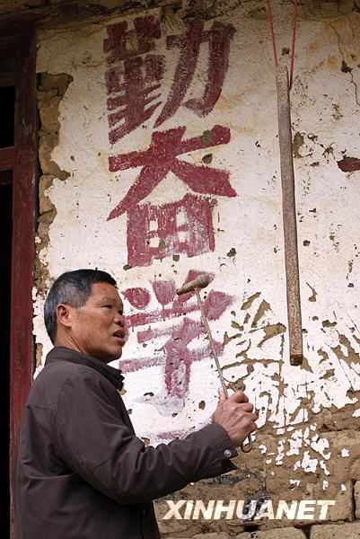 1月12日,在广西融水苗族自治县泗柳屯教学点,许振光老师打响上课钟.