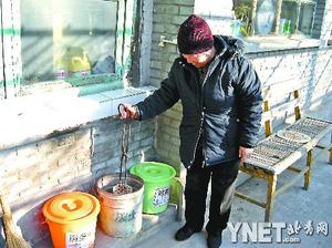 彭大妈正将烧过的煤放进家门口摆放的分类垃圾桶中■摄影 本报记者　赵媛媛
