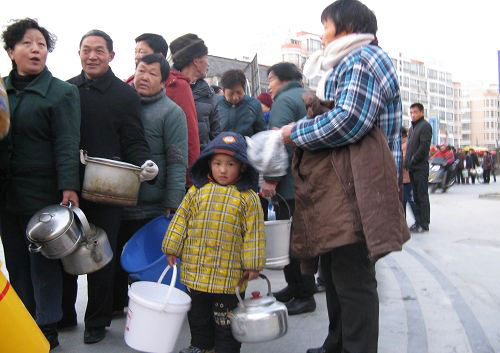 昨日，盐城市民提着各种器具等待政府送水