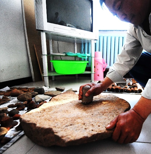 5月26日,文物工作者在展示从古城遗址采集的战国时代早期石磨盘
