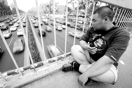 调查员在过街天桥上蹲守，筛查过往车辆 摄/记者杨威
