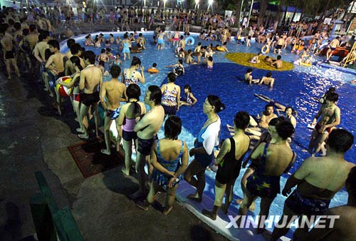 7月18日，武汉市民排长队等待进入泳池体验冲浪。