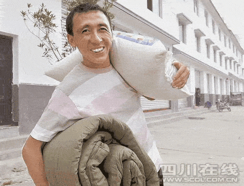 受灾户黎天陆领到发放的棉被和大米。 吴传明 摄