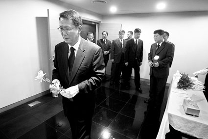 韩国驻华大使辛正承先生（前一）身着黑色西装、手戴白色手套，带领几位使馆工作人员，前往灵堂吊唁