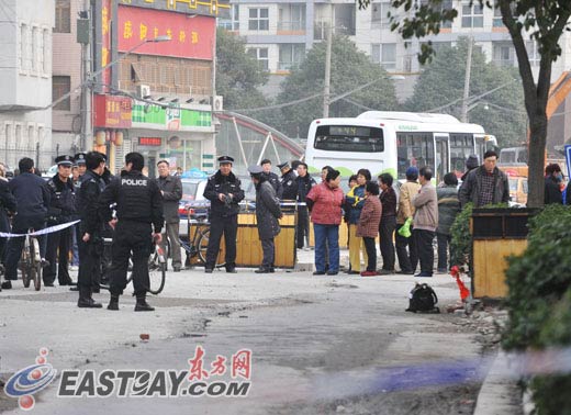 　图片说明:男子持刀挟持小孩的事件引发了众多群众围观。