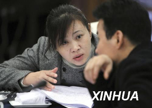 3月6日，全国人大代表胡小燕在会议间隙与其他代表讨论。新华社记者费茂华摄