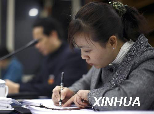 3月6日，全国人大代表胡小燕在会议上记笔记。新华社记者费茂华摄