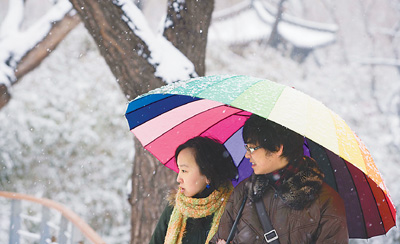 3月14日,北京飘起雪花,一对情侣在雪中散步吴家翔摄(人民图片)