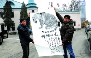 3月14日，爱虎人士、画家杨晶（左侧）展示作品，2006年曾为虎捐资5000元