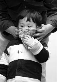 家长用围巾帮孩子遮挡风沙