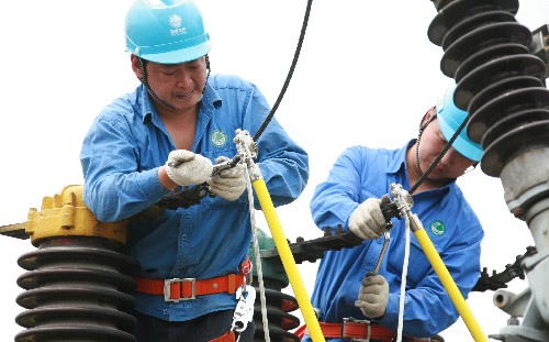 資料圖片 兩名電力工人在檢修電力設備. 新華社發(牛路 攝)