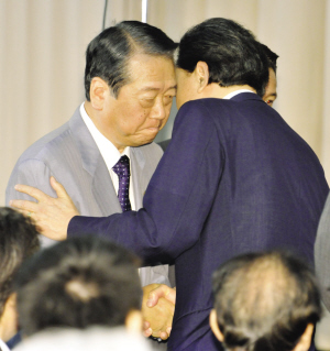 　　鸠山宣布辞职后与小泽一郎拥抱。