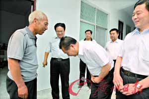 河南高院院长张立勇向赵作海（左）鞠躬致歉。 CFP供图