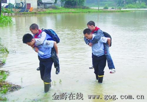 图文:贵州省暴雨不断 凤冈民警轮流背孩子上学