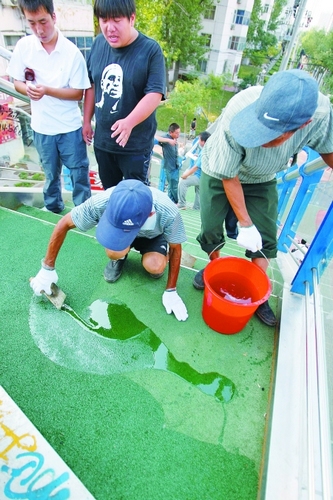 施工人員正在給地墊刷固化膠水