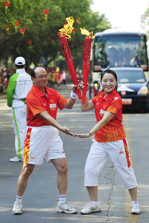 图文:亚运火炬在广东云浮传递 邓琦李顺松交接