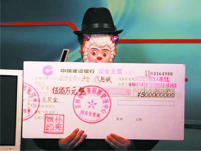 图为王先生在展示自己的大奖支票