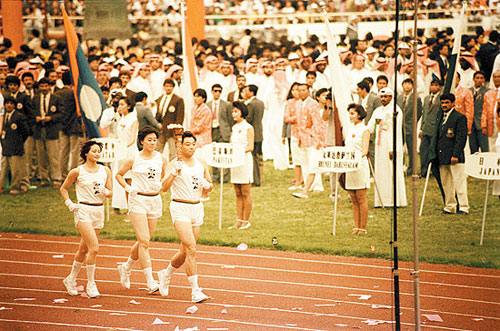 1990年北京亚运会开幕式，为中国体育实现奥运金牌“零”的突破的许海峰手挚火炬跑入会场。CFP供图 