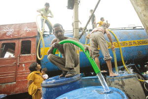 缺乏自来水设施的贫民窟住户只能靠水车接水度日
