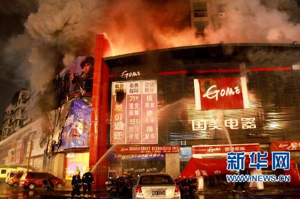 12月24日晚,消防人员在起火的国美电器商场外灭火