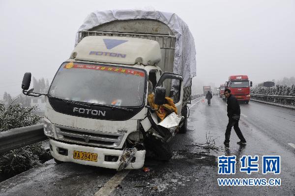 1月3日,贵州兰海高速公路修文段,一交警在事故车辆旁疏导交通.