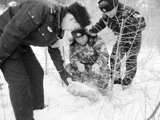 图为联合森林大队官兵在巡查时发现一只被钢丝套勒死的野兔.