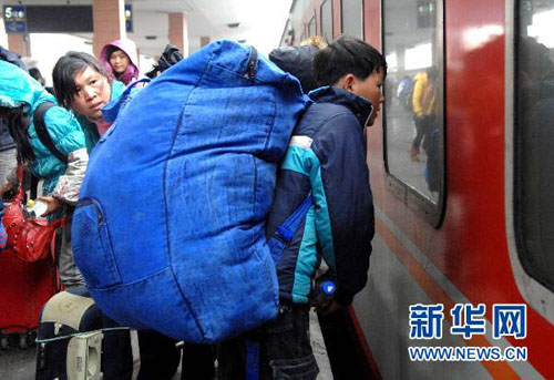 工人员背起沉重的行囊,满载着一年的收获,来到杭州火车站踏上回乡之旅